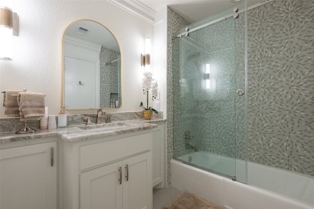 bathroom featuring bath / shower combo with glass door, vanity, and ornamental molding