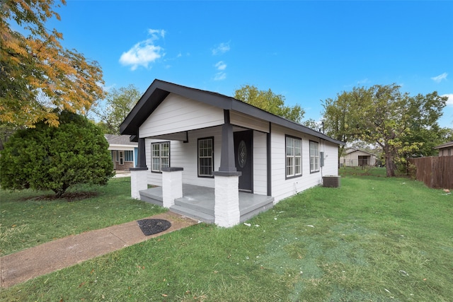 view of side of home with covered porch and a yard