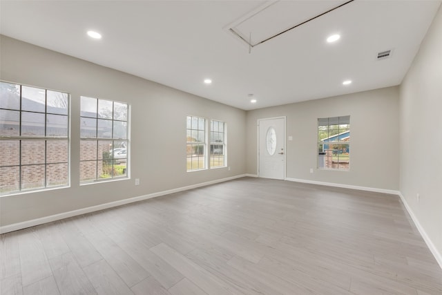 spare room with a wealth of natural light and light hardwood / wood-style floors