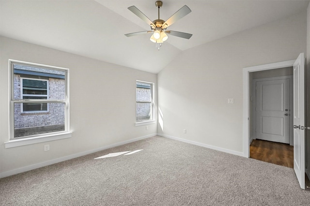 carpeted spare room featuring lofted ceiling and ceiling fan