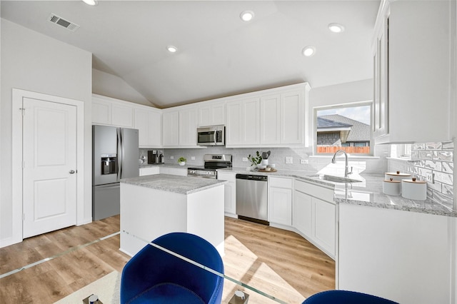 kitchen featuring sink, white cabinets, appliances with stainless steel finishes, and a kitchen island