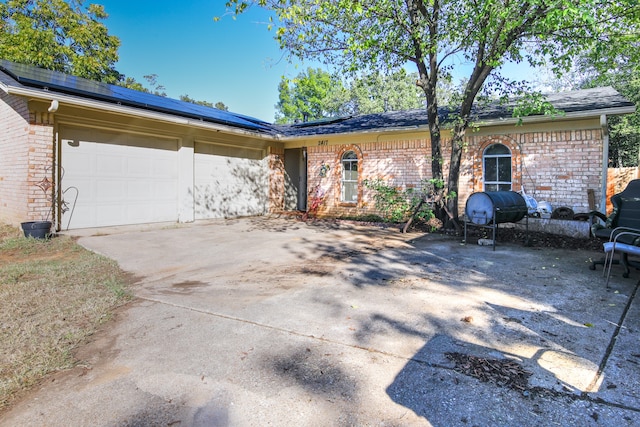 view of front of property with a garage and solar panels