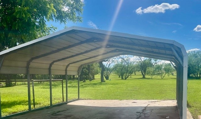 view of parking with a carport and a yard