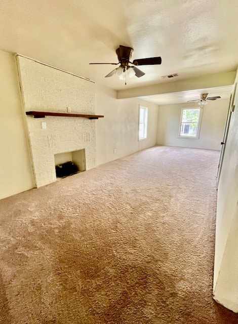 unfurnished living room featuring carpet, a textured ceiling, and ceiling fan