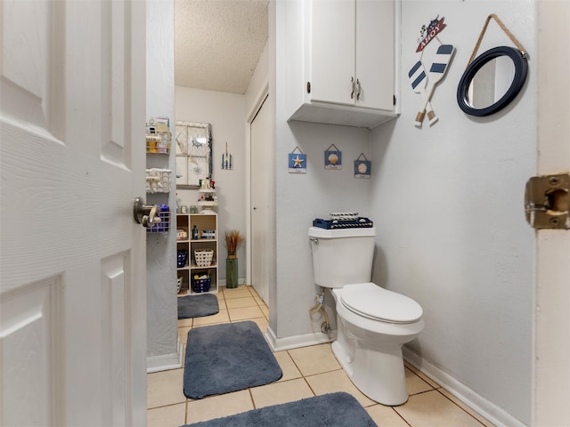 bathroom with tile patterned floors, a textured ceiling, and toilet