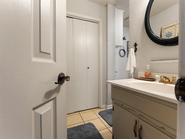 bathroom with tile patterned floors, vanity, and a textured ceiling