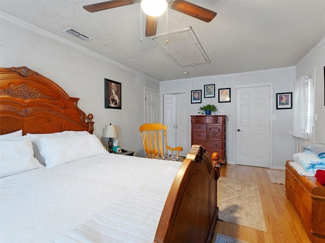 bedroom with a textured ceiling, light hardwood / wood-style flooring, ceiling fan, and crown molding