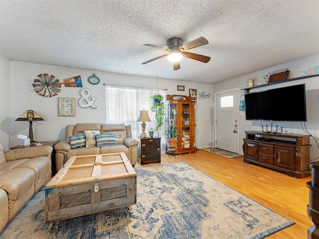 living room featuring hardwood / wood-style floors, a textured ceiling, and ceiling fan