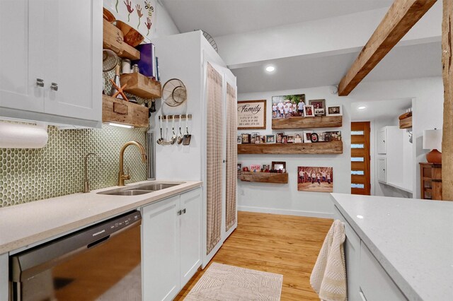 kitchen with decorative backsplash, light wood-style floors, white cabinetry, a sink, and dishwasher