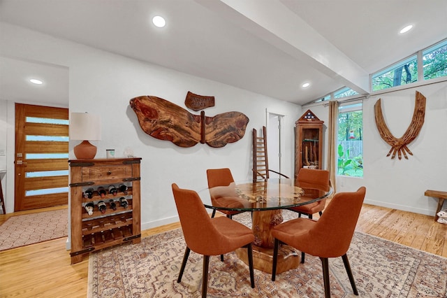 dining space featuring vaulted ceiling with beams, light wood finished floors, and baseboards