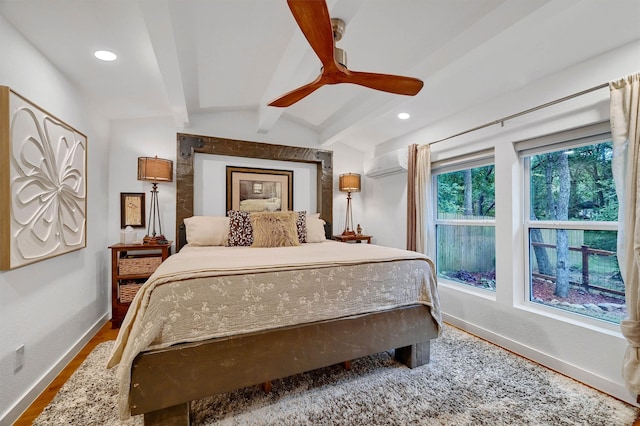 bedroom with lofted ceiling with beams, hardwood / wood-style flooring, a wall mounted air conditioner, and ceiling fan