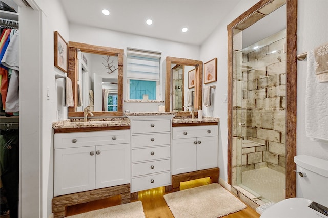 bathroom featuring an enclosed shower, vanity, hardwood / wood-style flooring, and toilet