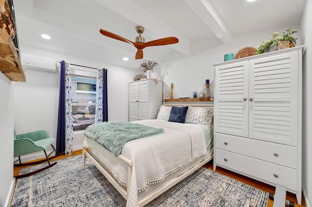 bedroom with a wall mounted AC, hardwood / wood-style floors, ceiling fan, and beam ceiling