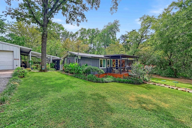 view of yard featuring a garage, a carport, and driveway