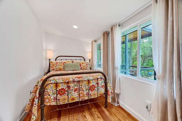 bedroom featuring wood-type flooring and multiple windows