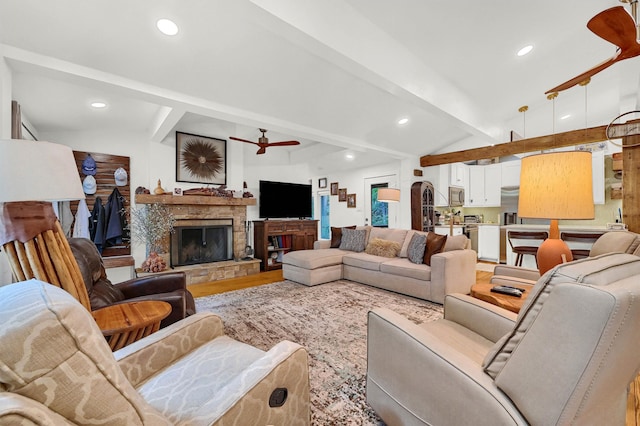 living room with lofted ceiling with beams, wood-type flooring, ceiling fan, and a fireplace