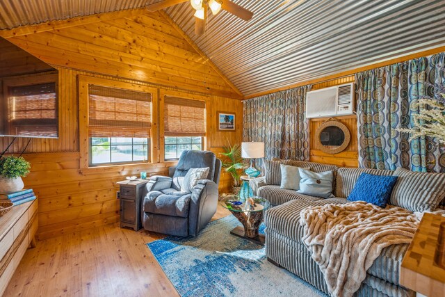 living room featuring wooden walls, ceiling fan, lofted ceiling with beams, light hardwood / wood-style flooring, and a wall mounted air conditioner