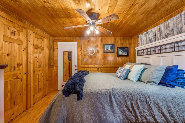 bedroom featuring wooden ceiling, ceiling fan, wooden walls, and light wood-type flooring