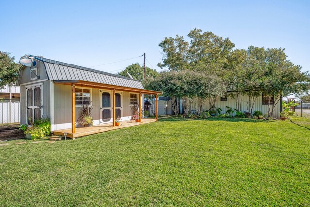 rear view of house with a lawn and an outdoor structure