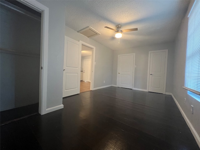 unfurnished bedroom with ceiling fan, dark hardwood / wood-style floors, and a textured ceiling