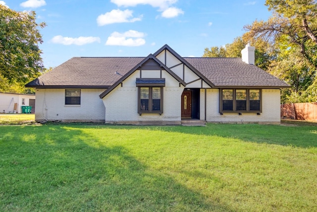 english style home featuring a front yard