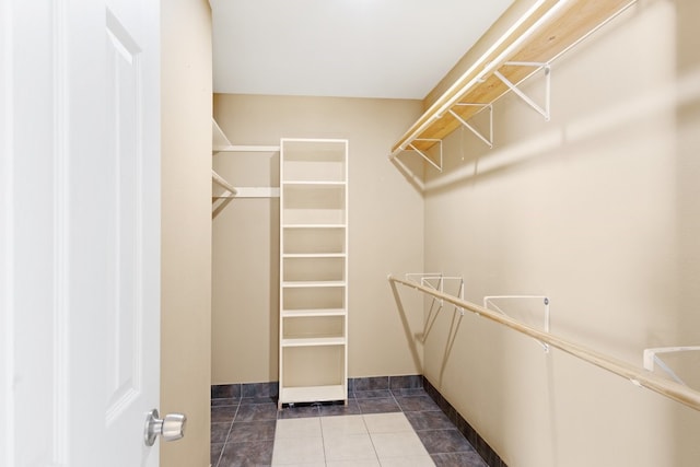 spacious closet featuring dark tile patterned flooring