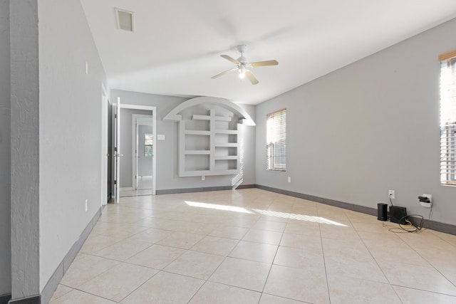 tiled spare room with built in shelves and ceiling fan