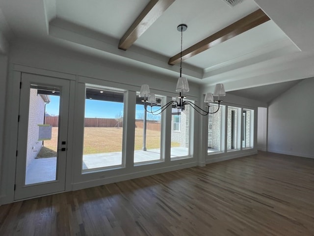 interior space with a raised ceiling, a wealth of natural light, dark wood-type flooring, and an inviting chandelier