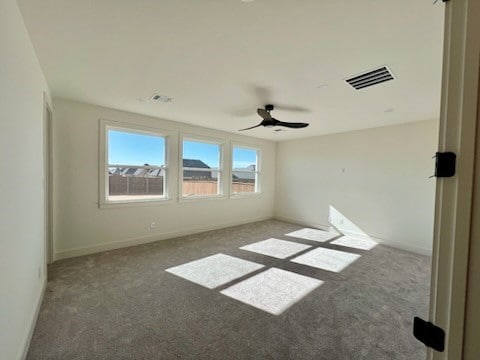 carpeted spare room with ceiling fan