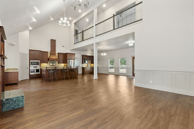 living room with a chandelier, dark hardwood / wood-style flooring, and high vaulted ceiling