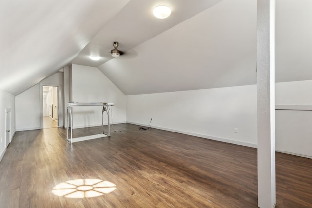 additional living space featuring vaulted ceiling and dark wood-type flooring