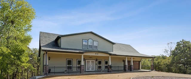 rear view of house featuring covered porch and a garage