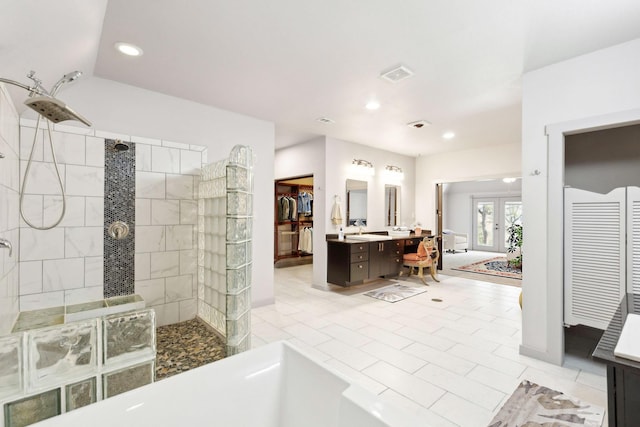 bathroom with tile patterned floors, vanity, tiled shower, and french doors