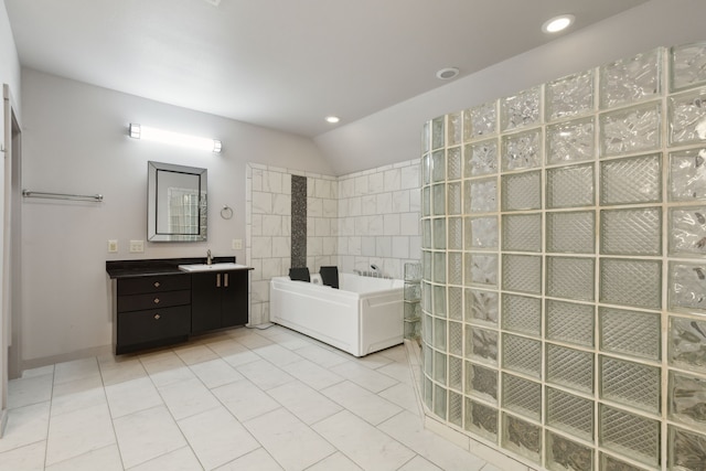 bathroom featuring vanity, vaulted ceiling, tile walls, tile patterned flooring, and shower with separate bathtub