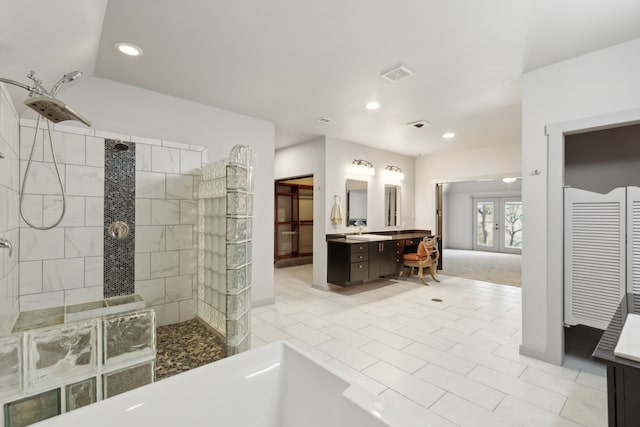 bathroom featuring a tile shower and vanity