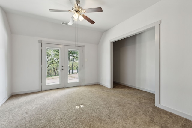 carpeted empty room with french doors, vaulted ceiling, and ceiling fan