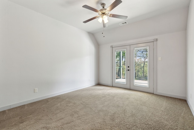 carpeted empty room with ceiling fan, french doors, and vaulted ceiling