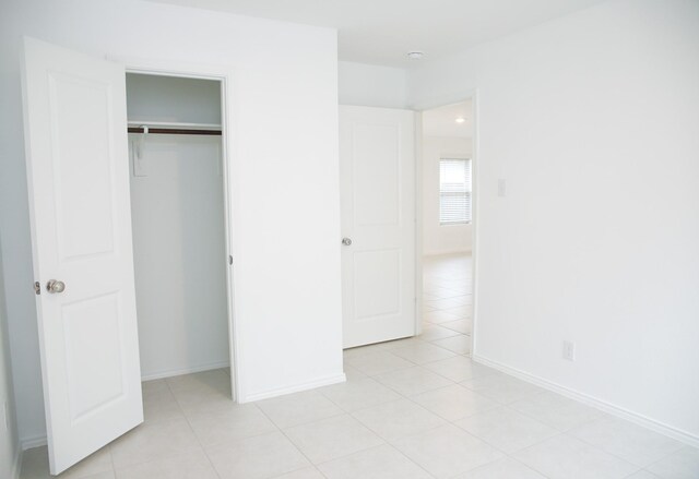 unfurnished bedroom with light tile patterned floors and a closet