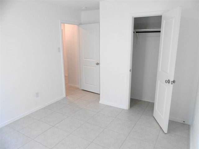 unfurnished bedroom with light tile patterned floors and a closet