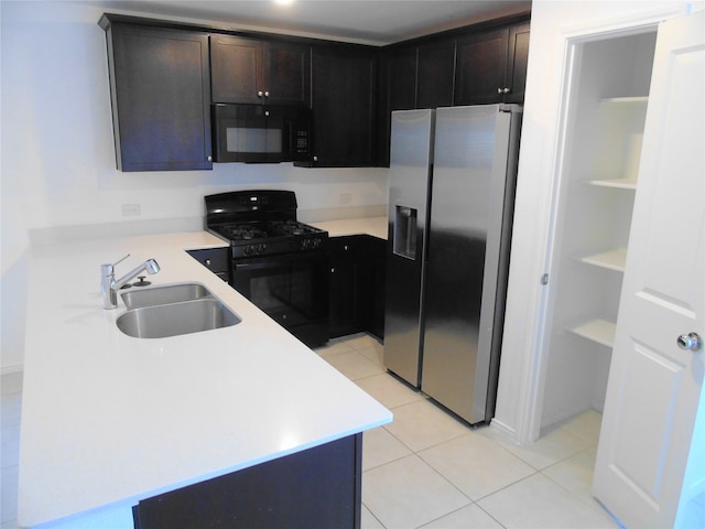 kitchen with light tile patterned floors, dark brown cabinets, sink, and black appliances