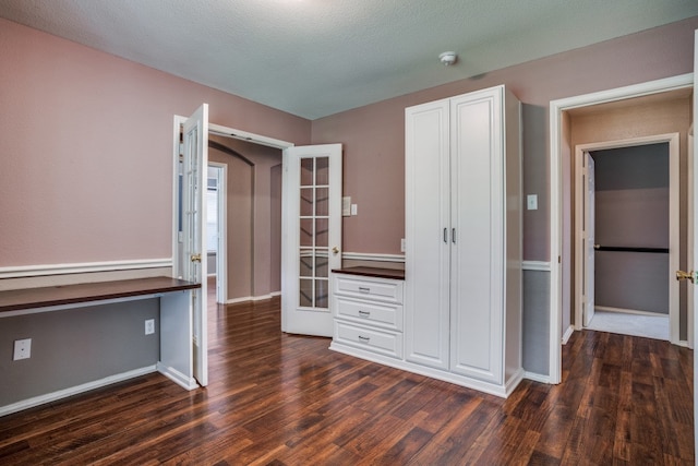 interior space featuring a textured ceiling, dark hardwood / wood-style flooring, and french doors