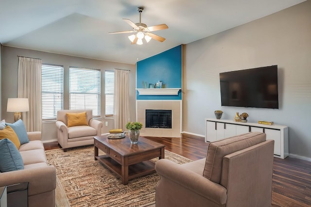 living room featuring dark hardwood / wood-style floors, ceiling fan, lofted ceiling, and a fireplace