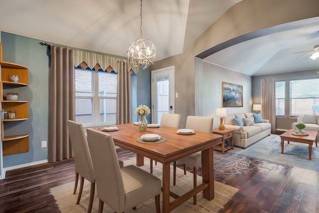 dining space with ceiling fan with notable chandelier, wood-type flooring, and lofted ceiling