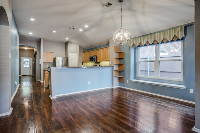 kitchen with light brown cabinets, dark wood-type flooring, stainless steel appliances, light stone counters, and vaulted ceiling