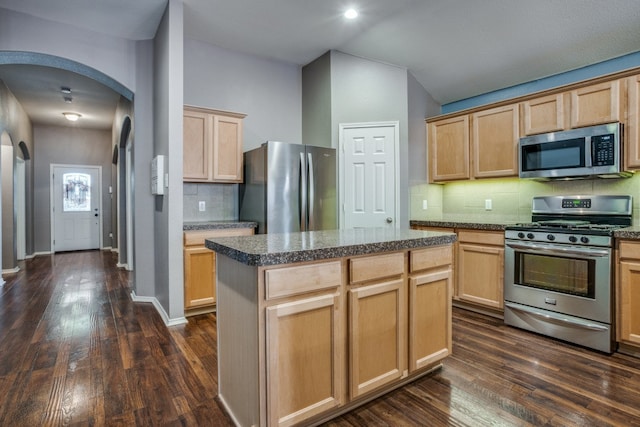 kitchen featuring light brown cabinetry, a kitchen island, dark hardwood / wood-style floors, and appliances with stainless steel finishes