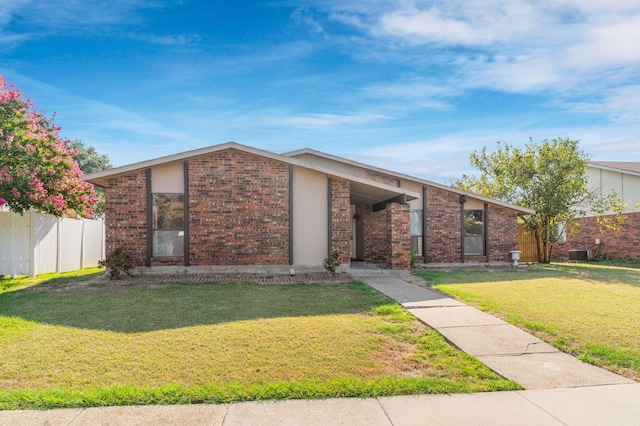 ranch-style house with a front lawn and central air condition unit