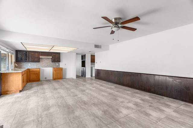 3312 Crater Ln, Plano, TX 75023 - kitchen featuring a ceiling fan, glass insert cabinets, a sink, backsplash, and light stone counters
