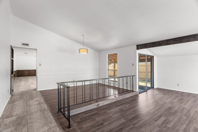 unfurnished room featuring dark hardwood / wood-style floors and lofted ceiling with beams