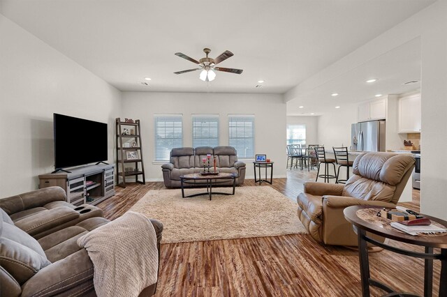 living room featuring light wood-type flooring and ceiling fan