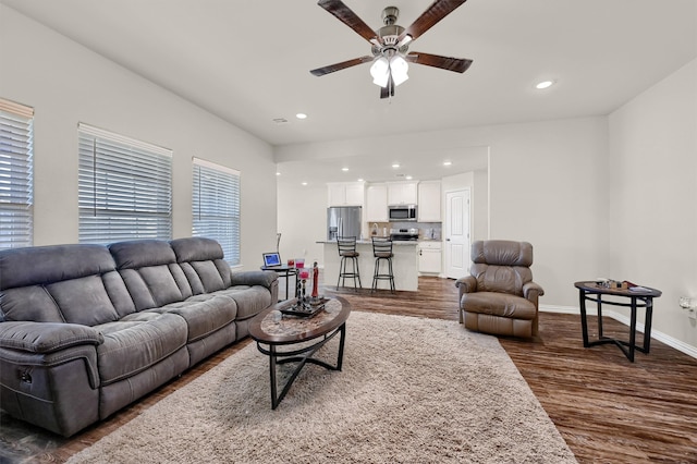 living room with ceiling fan and dark wood-type flooring